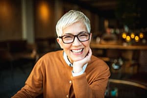 Woman smiling with glasses on and gorgeous smiling.