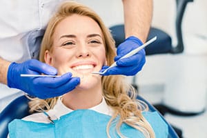 Woman getting teeth cleaned at dentist.