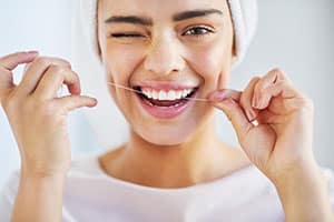 Woman flossing with white smile.