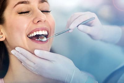 Woman having teeth examined at dentist office for dental implants near Royal Oak MI.