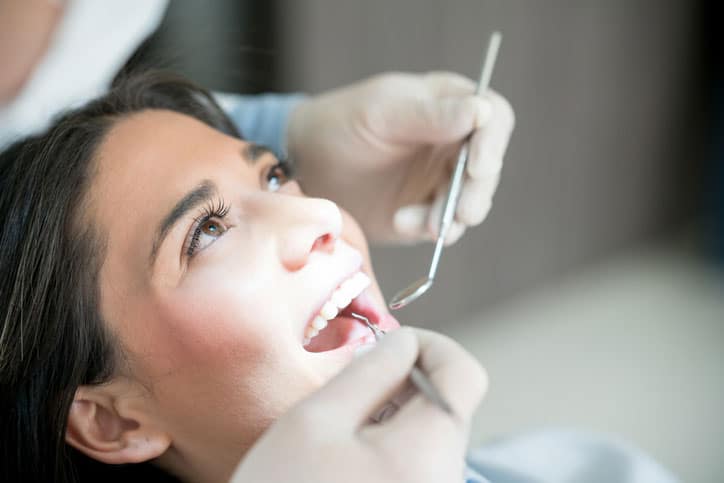 Portrait of a beautiful woman at the dentist getting her teeth checked - oral health concepts