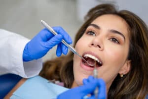 Portrait of a Latin American female patient at the dentist getting her teeth cleaned - dental health concepts
