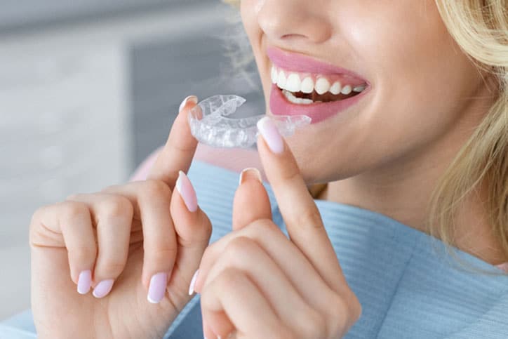 Woman Holding Clear Dental Aligners