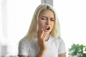 Woman Holding Mouth Sore