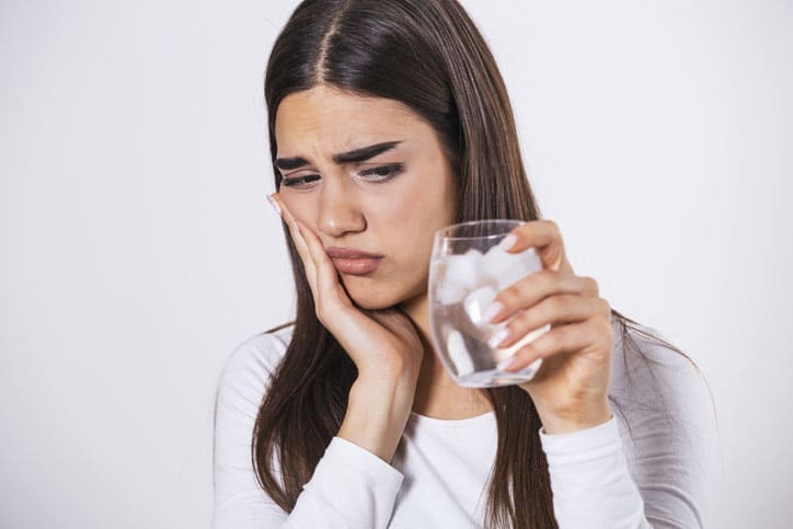 Woman Holding Jaw and Ice Water for Sensitive Tooth Pain