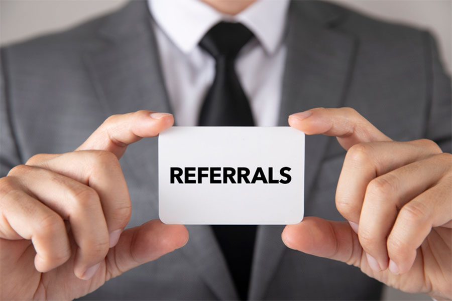 Business Man holding Referrals card