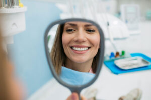 Woman Holding Mirror in Dental Chair