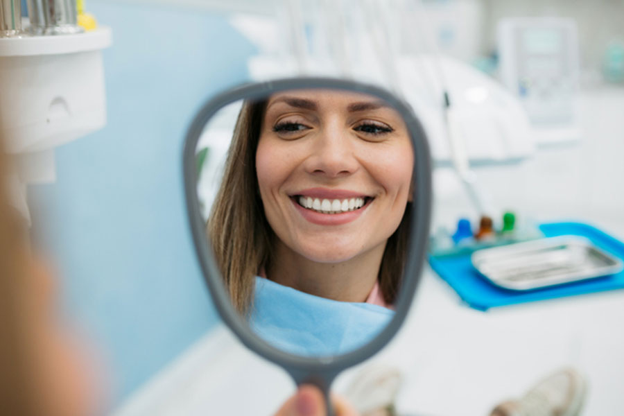 Woman Holding Mirror in Dental Chair