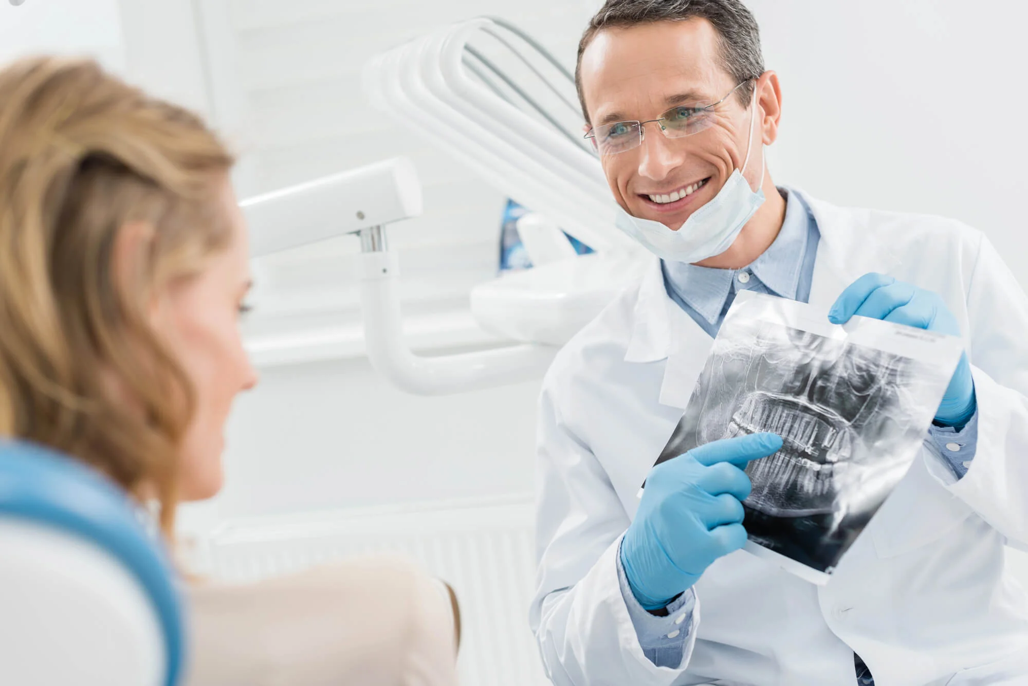 Dentist in Royal Oak, MI explaining dental X-ray results before tooth extraction procedure.