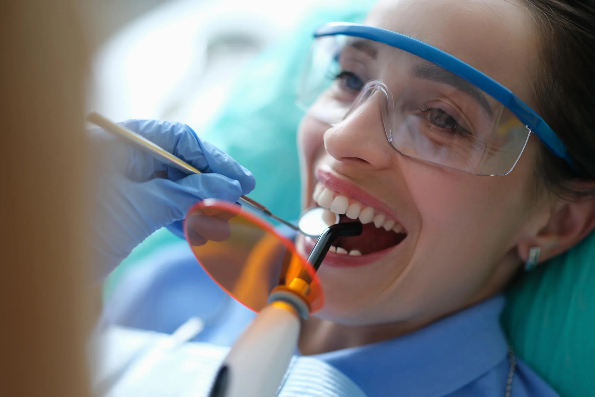 Dentist providing restorative dentistry in Birmingham, MI by adjusting a custom ceramic crown.