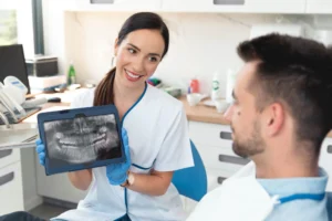 A cosmetic dentist Birmingham, MI showing X ray to a male patient.