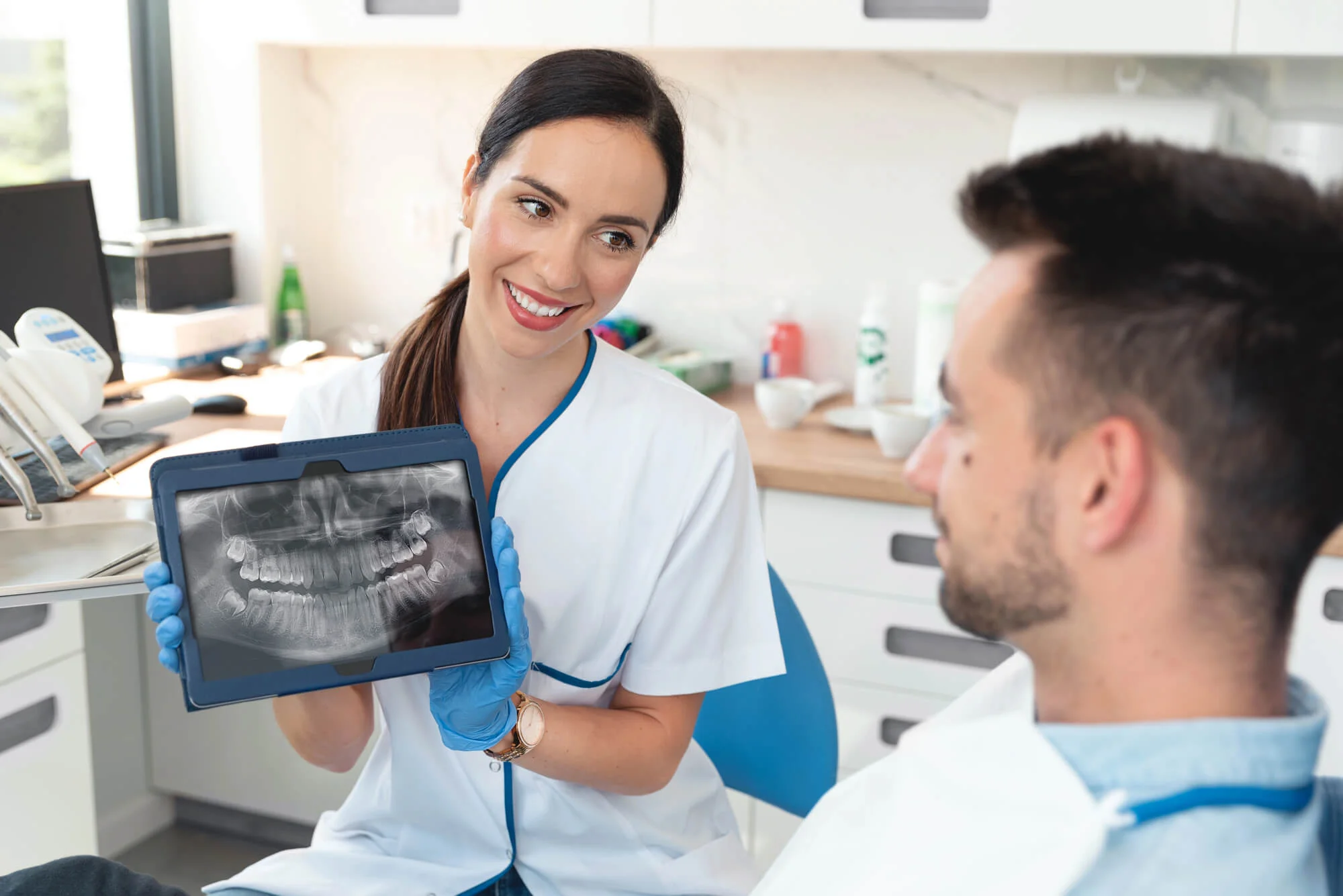 A cosmetic dentist Birmingham, MI showing X ray to a male patient.