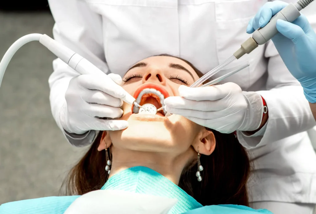 Dental hygienist performing teeth cleaning in Birmingham, MI.