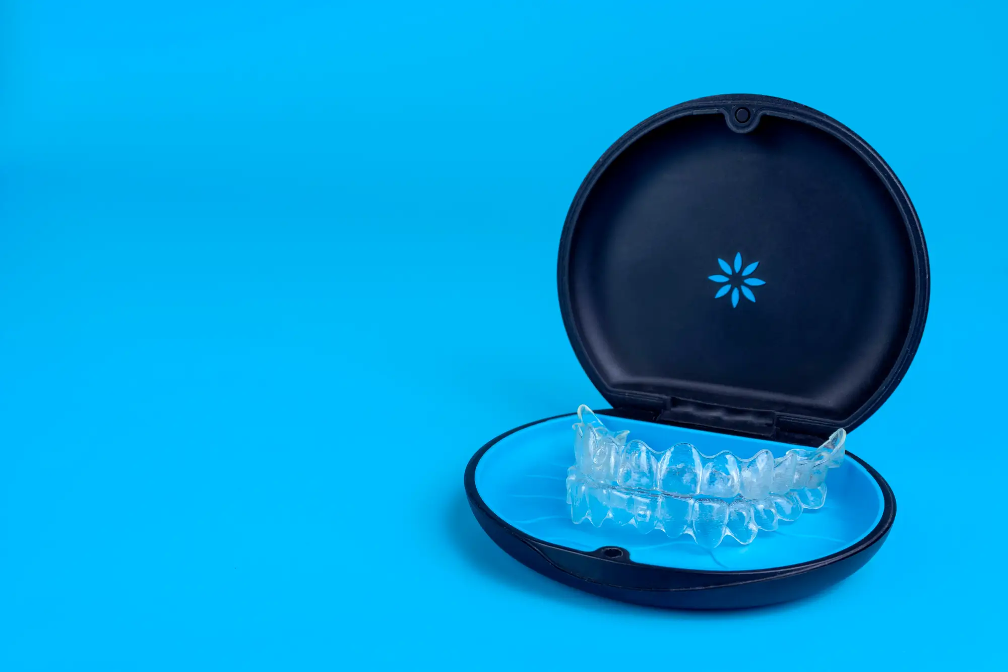 Invisalign case and aligners illustrating how to clean teeth with Invisalign.